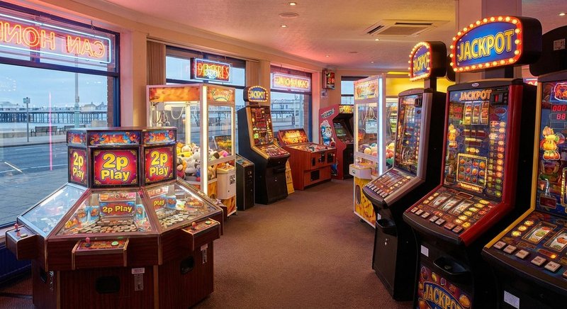 AWP machines in a British seaside family arcade — Category D coin pushers, crane grabs and reel machines